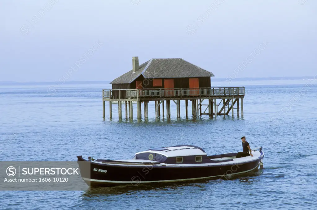 France, Aquitaine, Gironde, Arcachon bay, fisherman in boat, stilt cabin