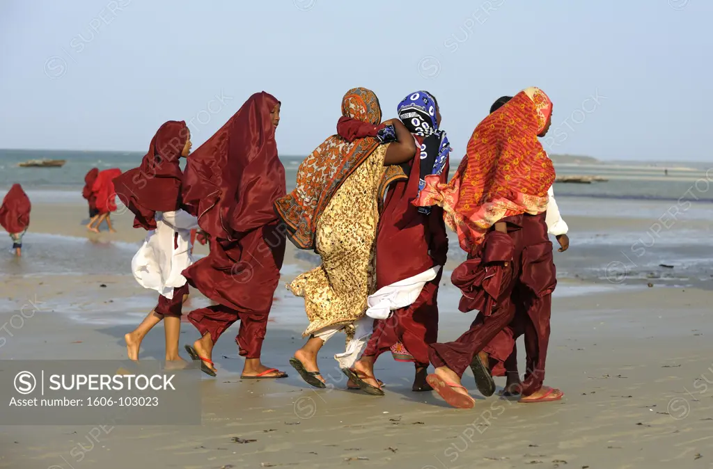 Tanzania, near Dar es Salaam, South Coast, young women walking on the beach