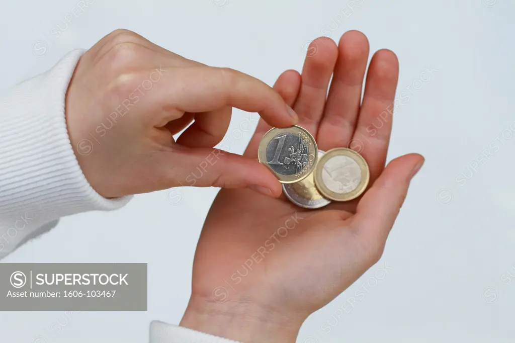 Child hands holding euro coins