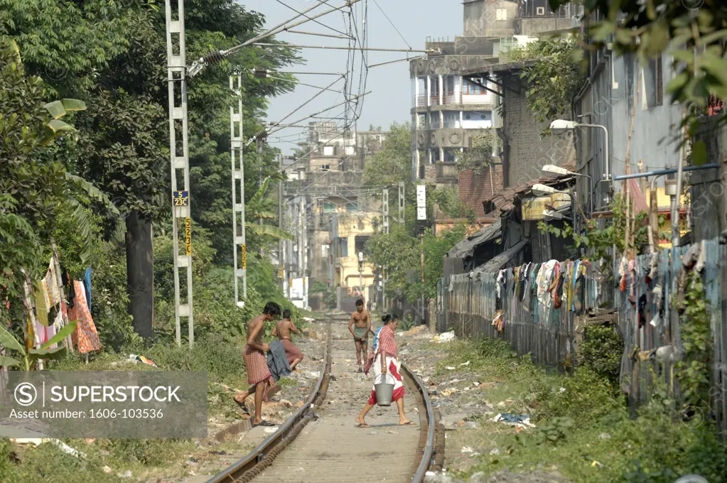 India, West Bengal, Kolkata, people crossing railway tracks