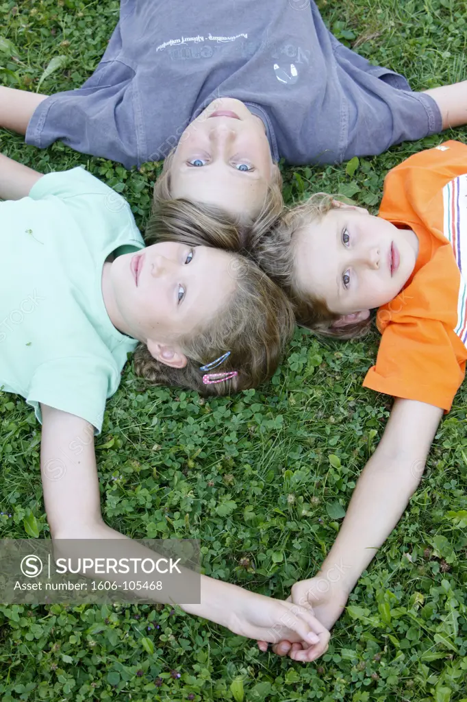 France, Haute Savoie, Saint-Gervais, Children lying in grass