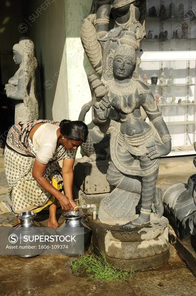 India, Tamil Nadu, Mahabalipuram, femme remplissant bidons d'eau, statues