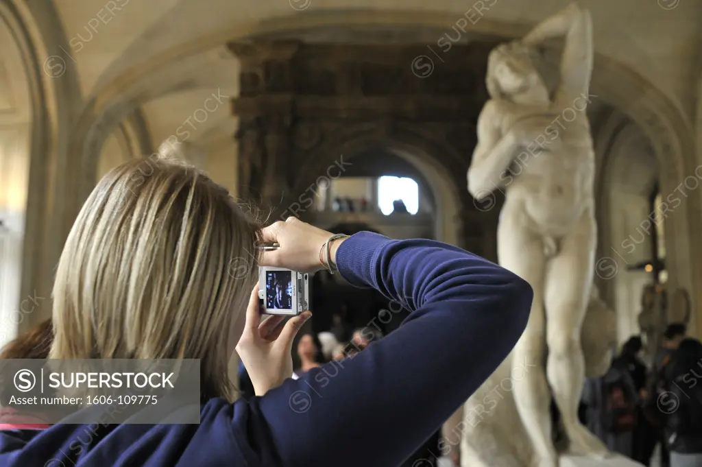 France, Paris, Louvre museum, tourist photographing a statue