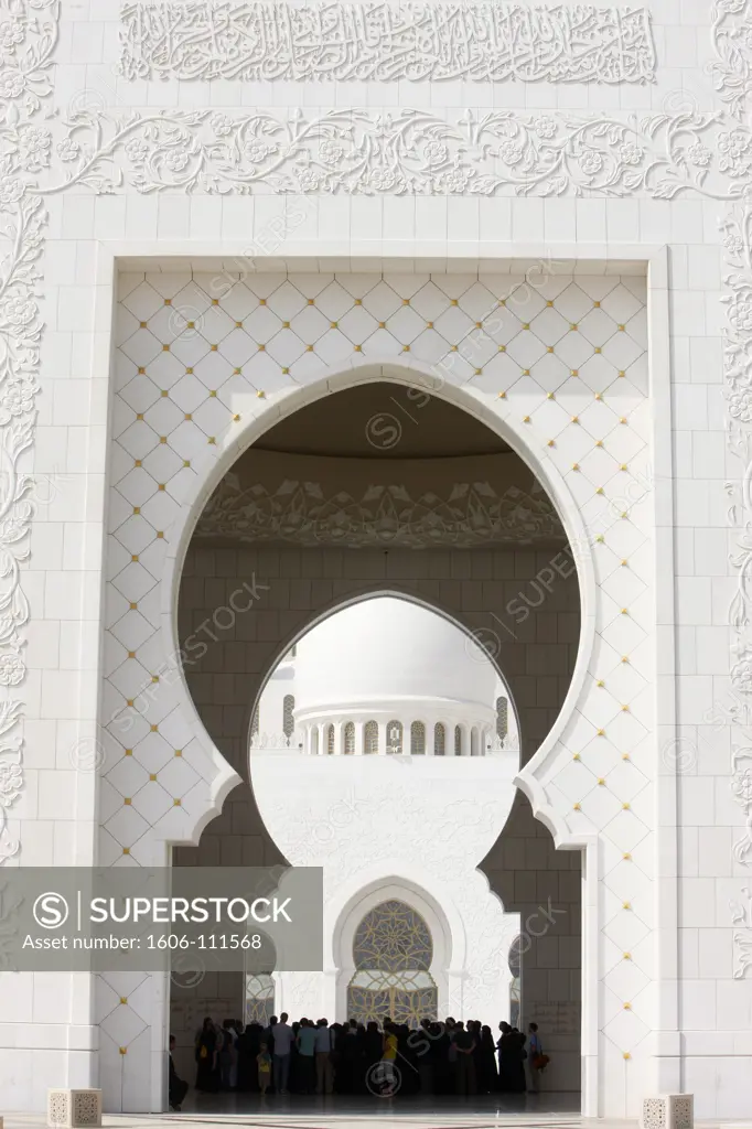United Arab Emirates, Abu Dhabi, Abu Dhabi, Sheikh Zayed Grand Mosque. The main entrance is inlaid with text from the Koran and botanical images skilfully carved into the marble arches
