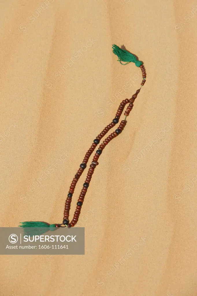 United Arab Emirates, Abu Dhabi, Abu Dhabi, Muslim prayer beads on desert sand