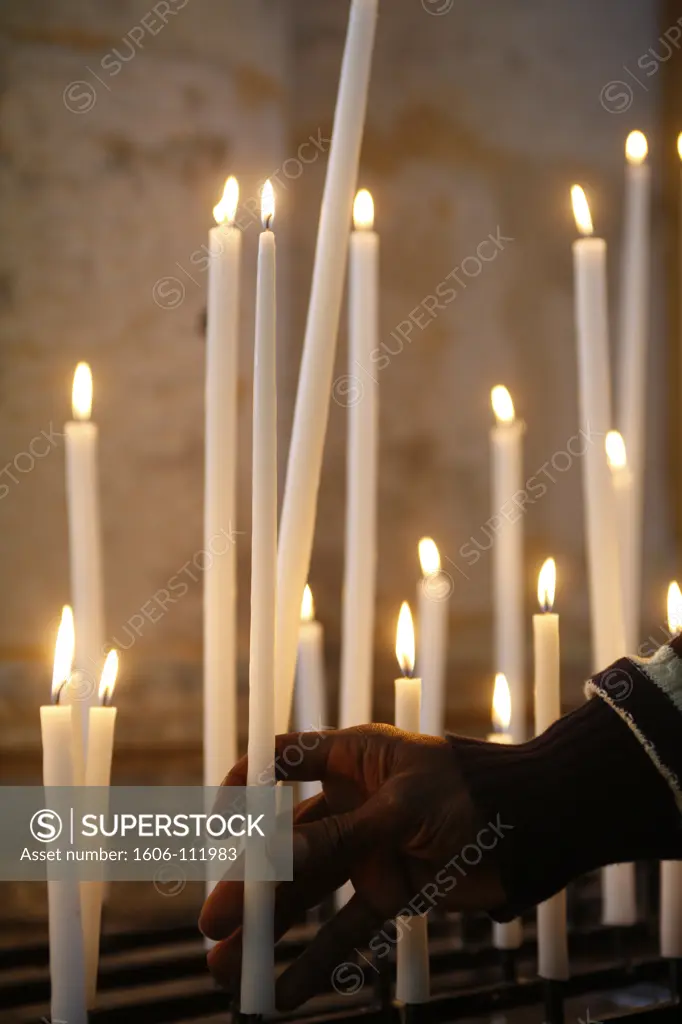 France, Somme, Amiens, Man praying with candles in church