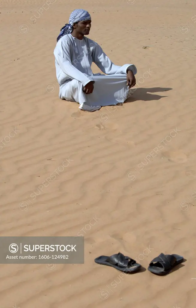 Sultanate of Oman, Ash Sharqiyah, Wahiba Sands, bedouin man sitting in sand