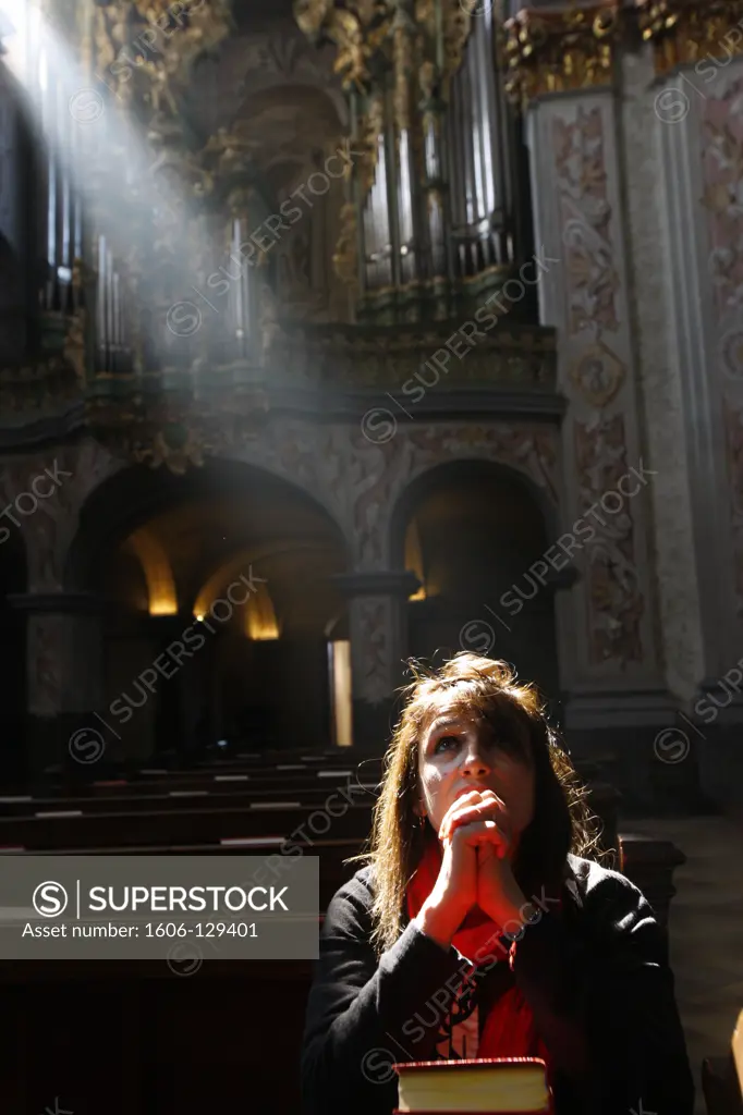 Austria, Lower Austria, Herzogenburg. The  baroque church of the abbey of Herzogenburg.  Woman praying.  Austria.