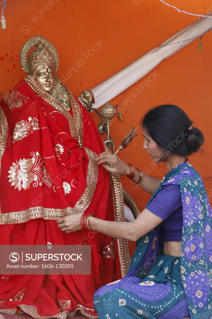 India, Uttarhakand, Haridwar. Hindu woman dressing a Durga statue in Pilot Baba camp at Kumbh Mela in Haridwar India.