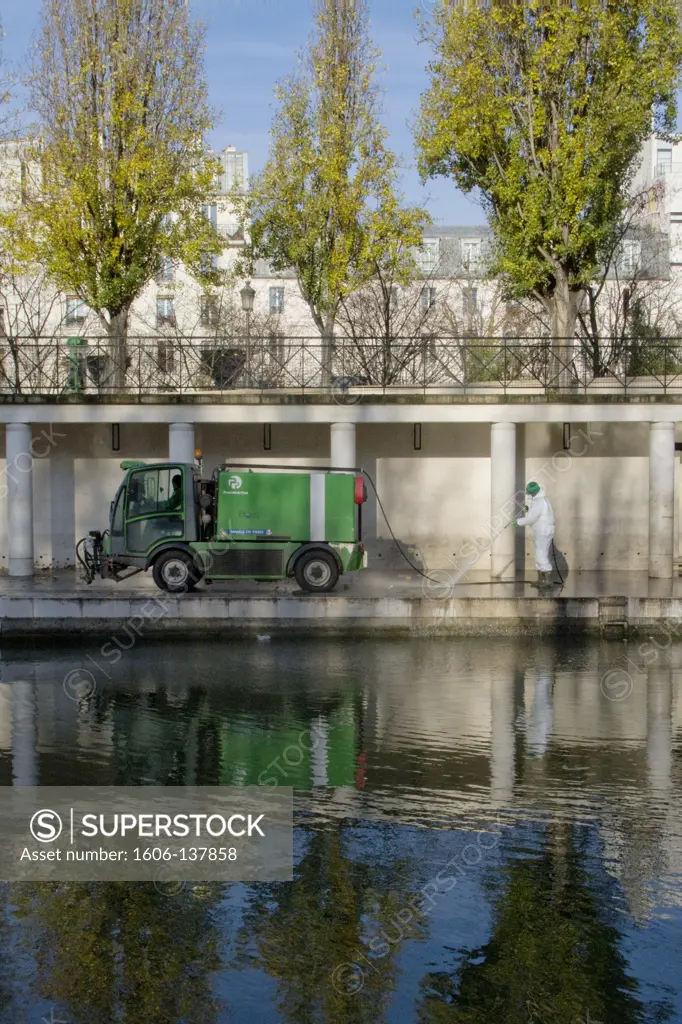 France, Paris, man cleaning bank of Bassin de la Villette