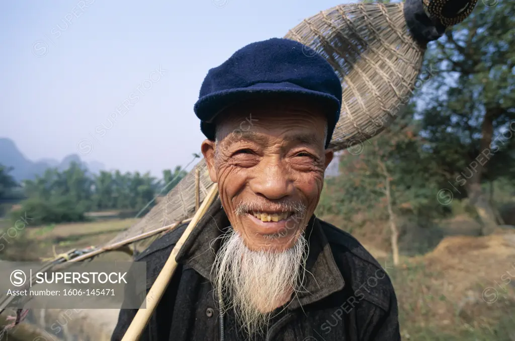 China, Guangxi Province, Guilin / Yangshou, Elderly Fish Farmer with Traditional Fishing Basket
