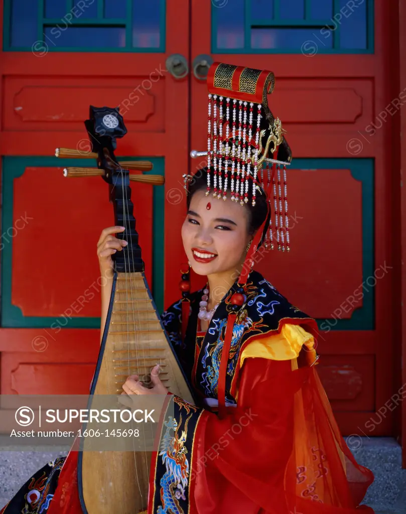 China, Beijing, Women Dressed in Traditional Costume Playing Musical Instrument / Three String Lute