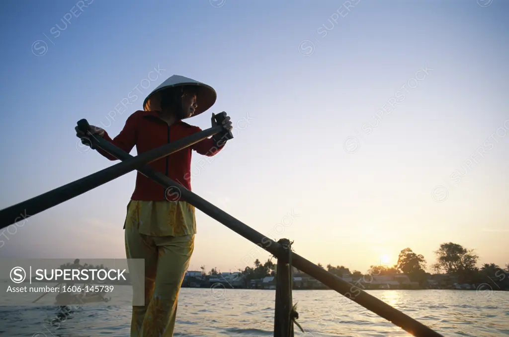 Vietnam, Mekong Delta, Cantho, Boat Woman on Mekong River / Sunrise