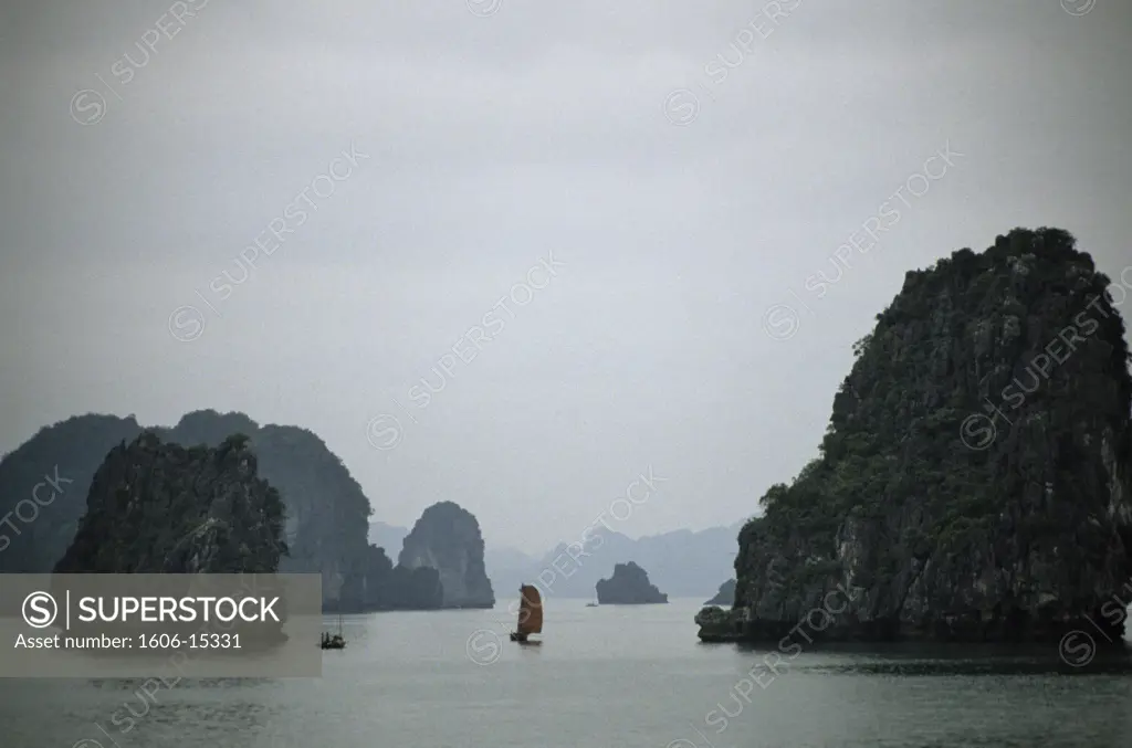 Vietnam, Halong bay, general view, junk  and boat in the foreground, rocks, mist