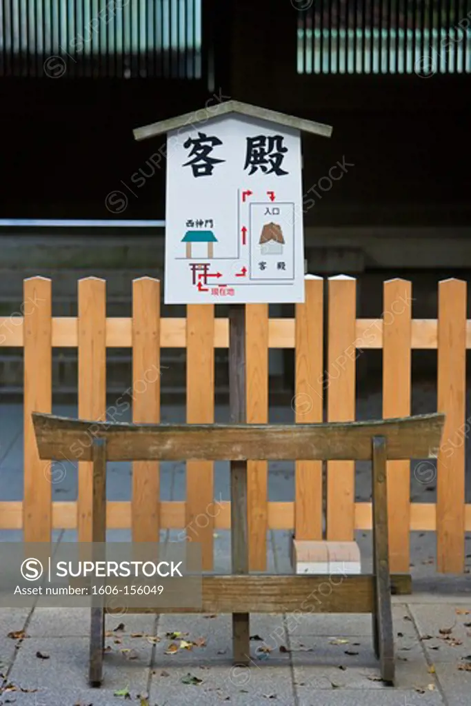A directional sign reflects elements of traditional Japanese architecture at the entrance to the central sanctuary of Meiji-Jingu Shrine, located in the Shibuya district of Tokyo, Japan.