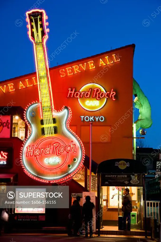 Tokyo's Hard Rock Cafe has a neon guitar and King Kong hanging off the roof at twilight in the upscale Roppongi District of Tokyo, Japan.