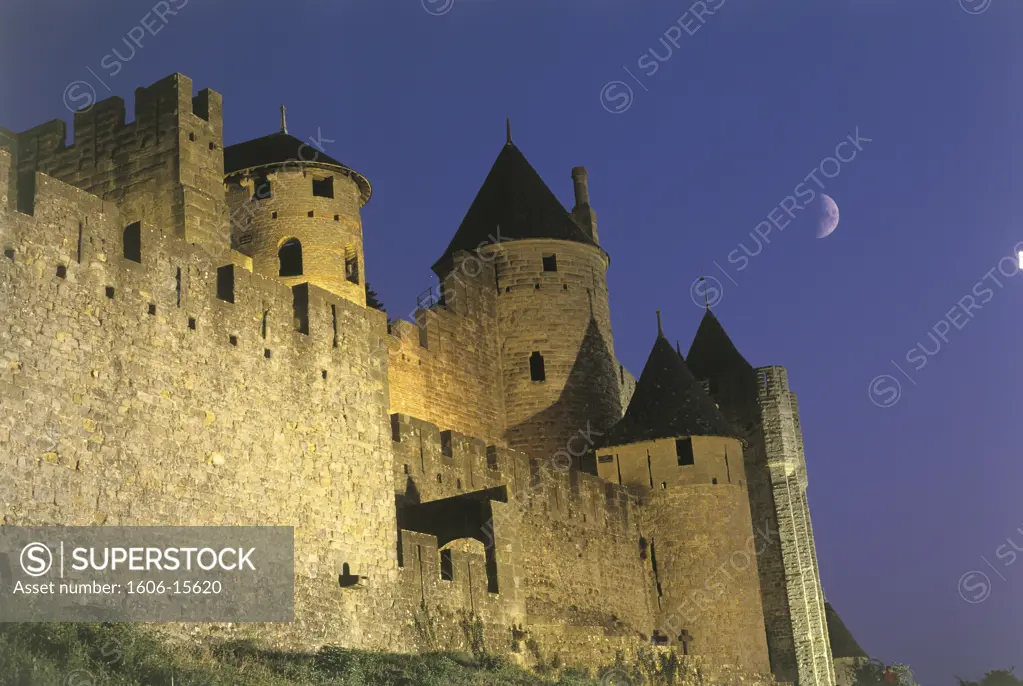 France, Languedoc Roussillon, Aude, Carcassonne at night, illuminated ramparts, low angle view, moon