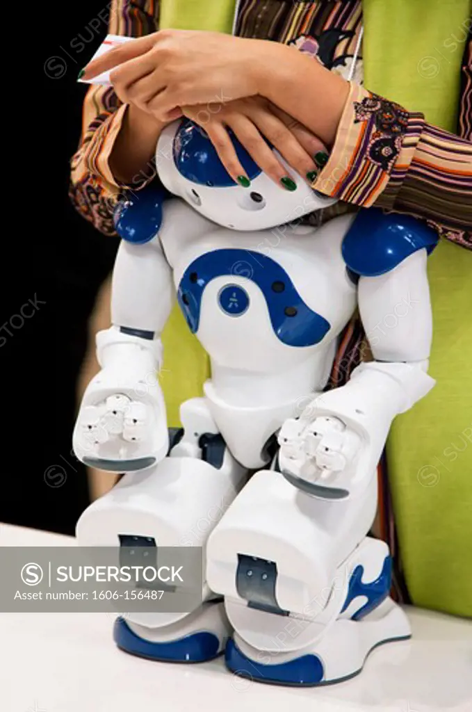 A staff member rests her hands on a demonstration service robot at the annual International Robot Exhibition, which attracts industry professionals as well as tech-geeks to Tokyo Big Sight, a modern convention center located in the Odaiba District o ...