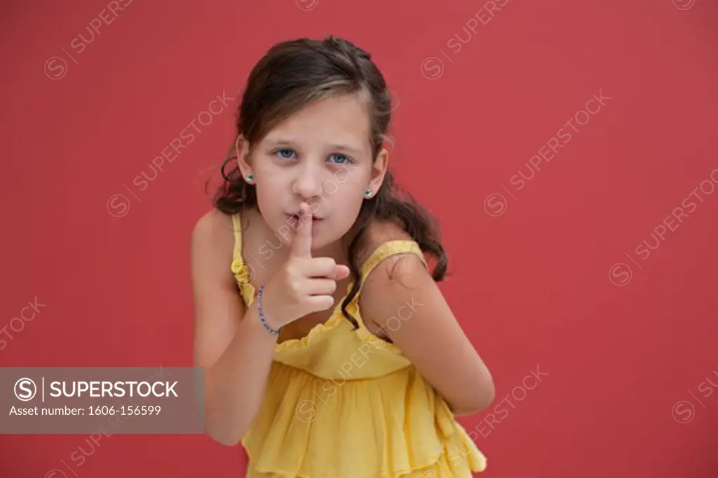 Girl putting her finger on her lips as a sign of silence