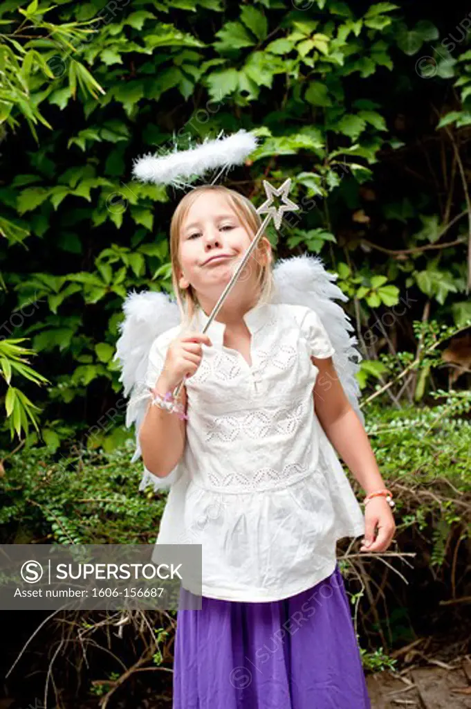 Girl dressed as an angel, holding a magic wand