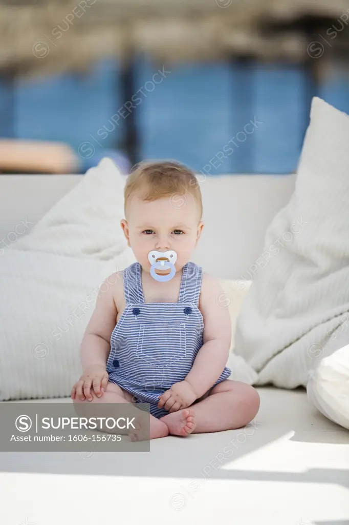 Portrait of a 1 year boy at the beach with pacifier