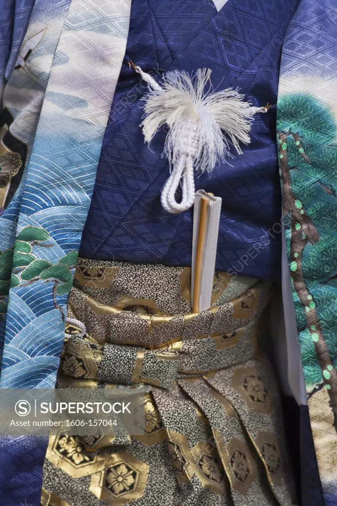 A detailed view shows the traditional kimono of an older man visiting Kitano Tenmangu Shrine in Kyoto, Japan.