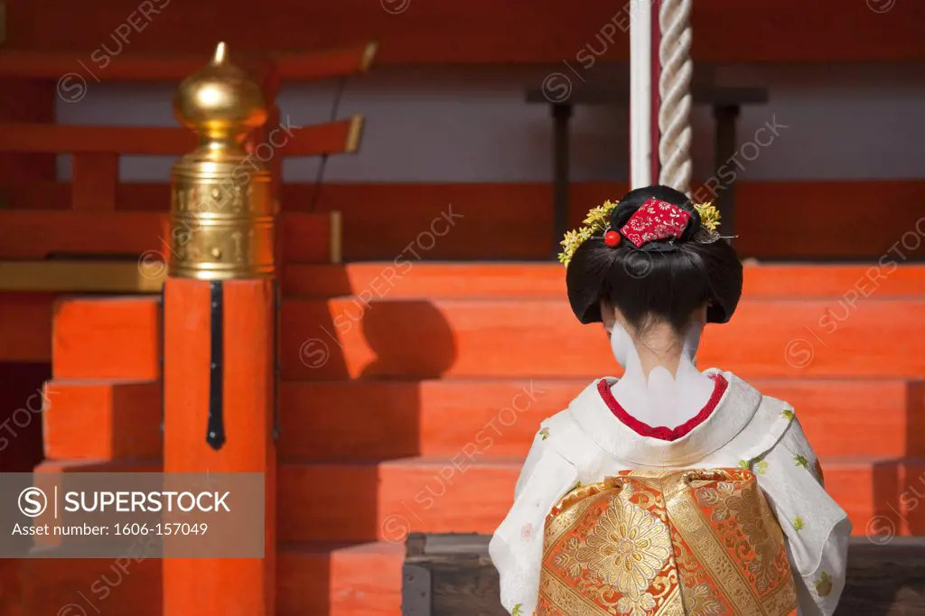 A maiko geisha visits Kitano Tenmangu Shrine in Kyoto, Japan.