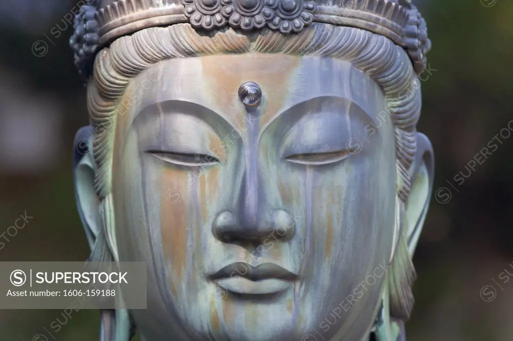 A detailed view shows the serene countenance of a Buddha statue in the Treasures Museum garden at iNinnaji Temple, a World Heritage Site located in the northern area of Kyoto, Japan.