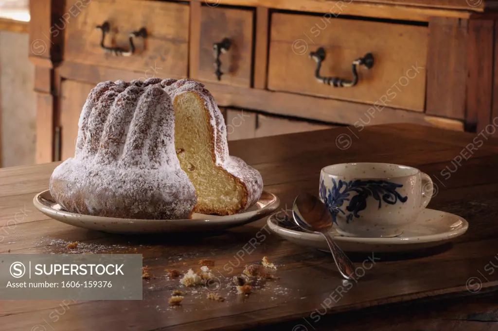 France, 68, Kougelhopf sprinkled sugar on a wooden table ""pastry""