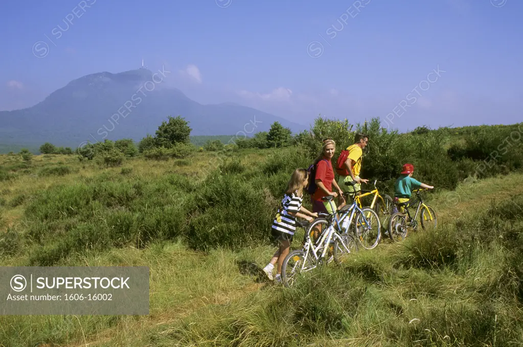 Family with bicycles in country in summer