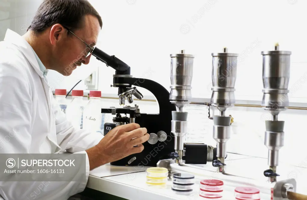 Laboratory, man analyzing waters with microscope
