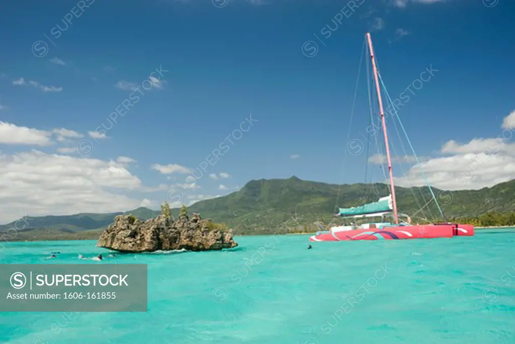 Catamaran moored at l'île aux Bénitiers close to a coral rock, Mauritius, Indian Ocean