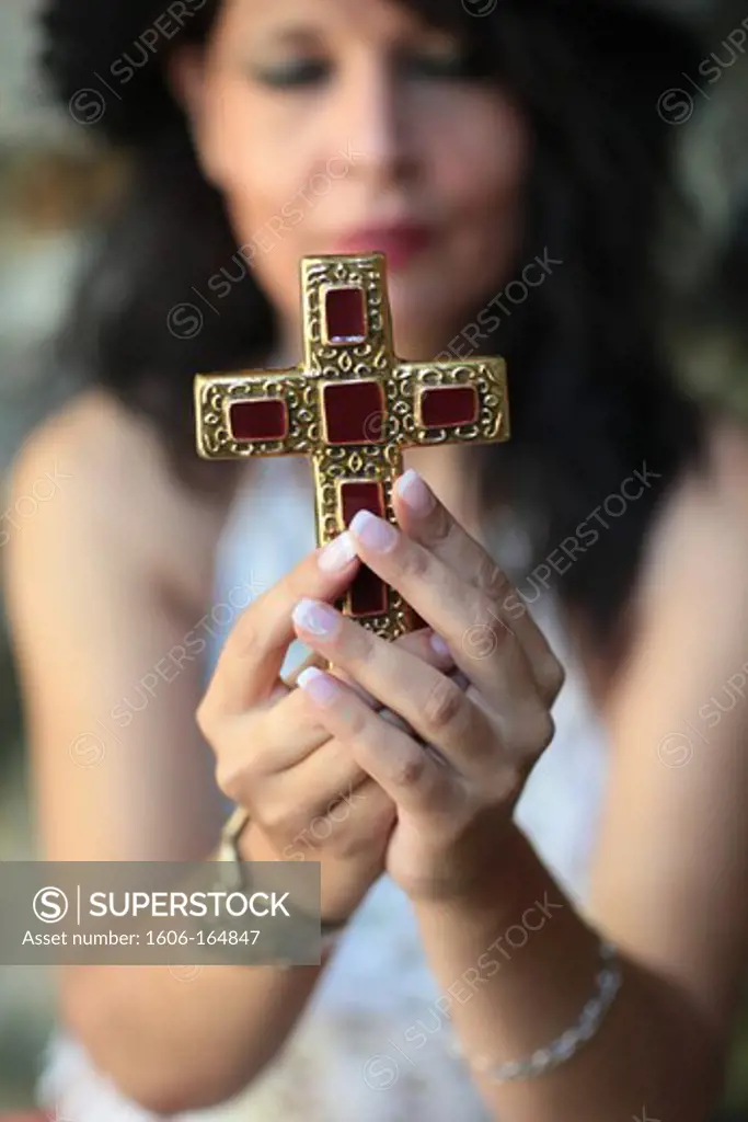 Christian woman praying with a cross. Saint-Gervais. France.