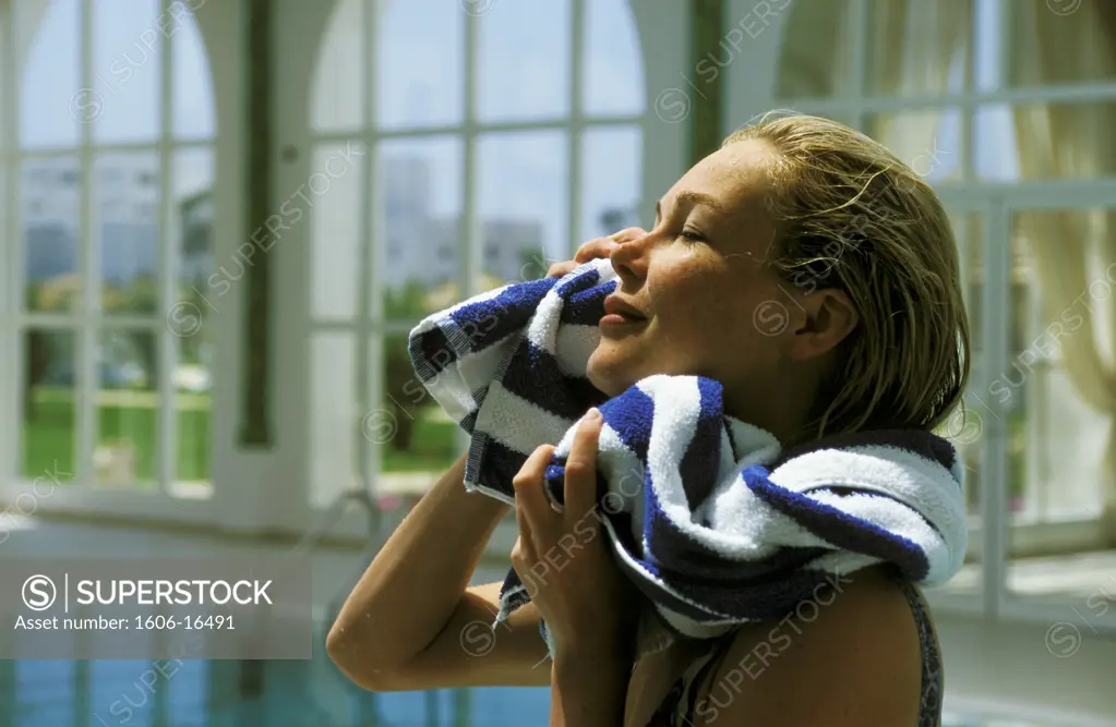 Portrait of woman drying her face, indoor pool
