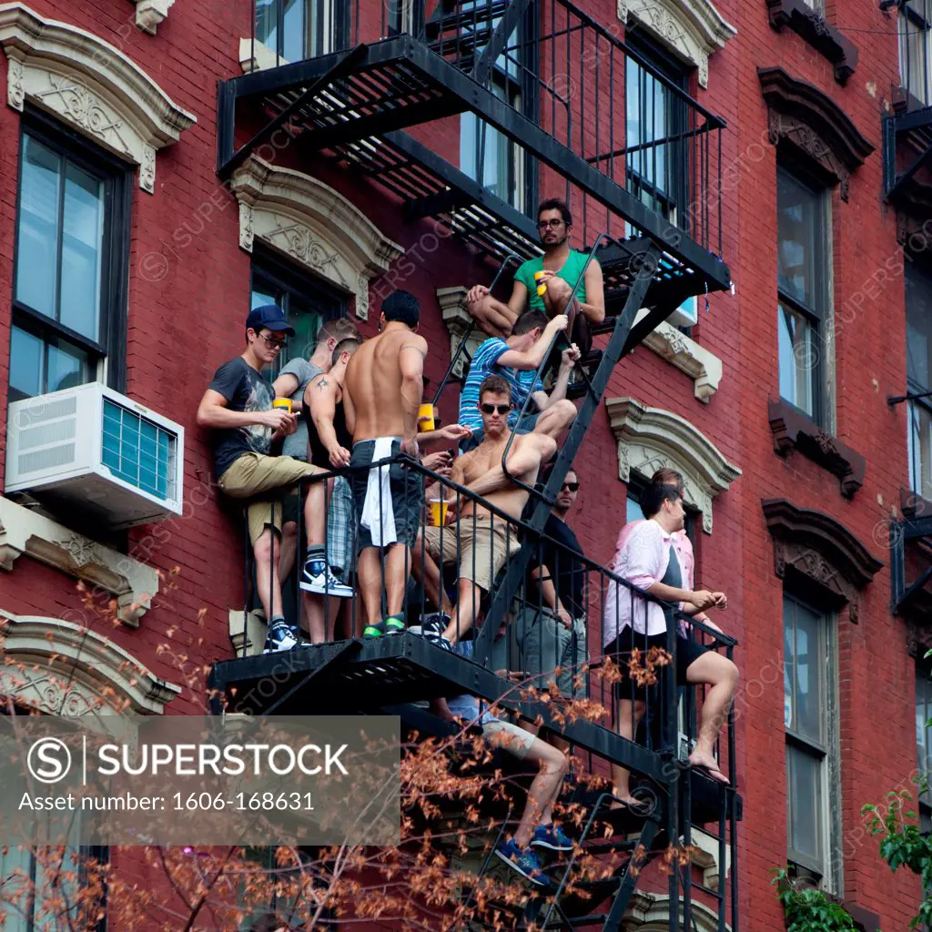 New York - United States, gay pride parade on fifth avenue, men sitting on a fire exit stairs