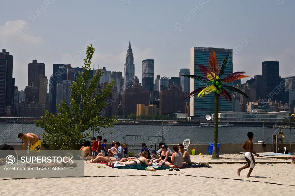 New York - United States, people sunbathing on a fake beach at Harry's, Water Taxi Beach, bar, beach, volley at Long Island city in front of Midtown Manhattan