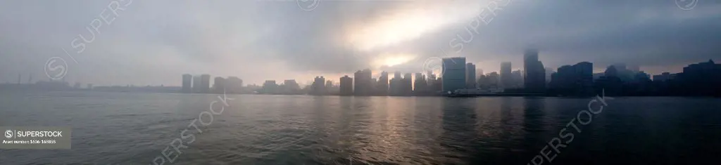 New York - United States, Manhattan Skyline with a very strange and spectacular light, dusk, view from Long island city quays, new real estate project in Queens