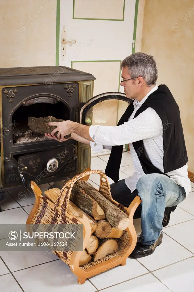 man lighting a fire at home, France
