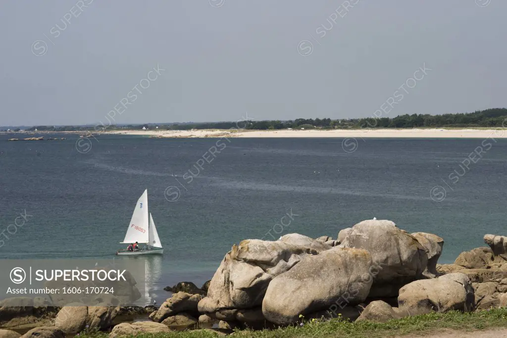 Small sailboat sailing along by the rocky coast in Trevignon, Tregunc, Finistère, Britany, France