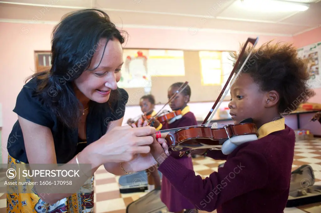 South Africa, Cape Town, Township of Gugulethu, Primary school, teacher helping her students to play violin