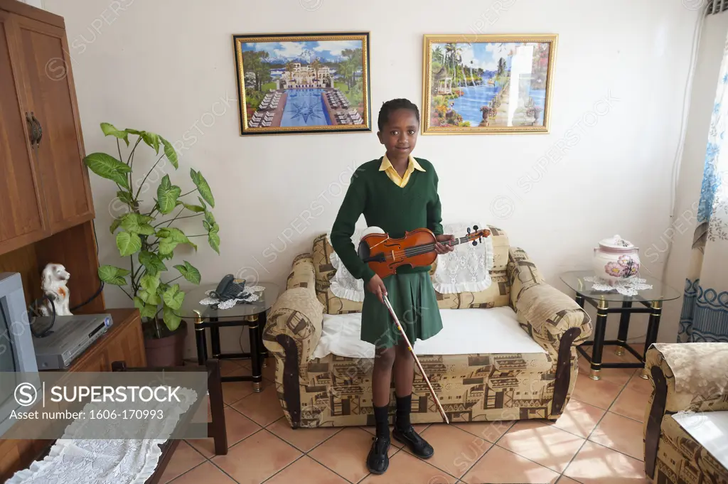 South Africa, Cape Town, Township of Nyanga, student in a living room ready to play violin