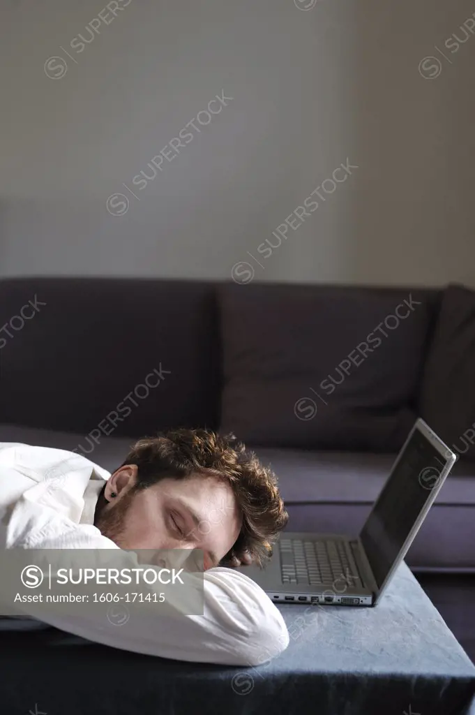 Man using a laptop at home, sleeping