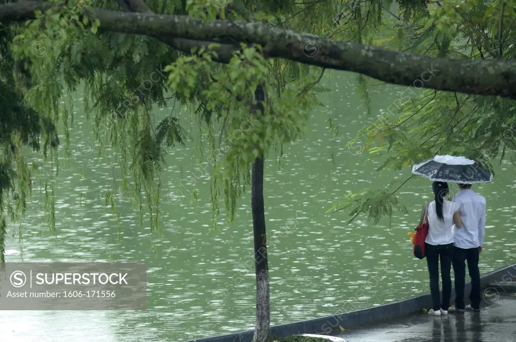 Asia, Southeast Asia, Vietnam, Hanoi, lake Hoan Kiem, couple gazing the lake under the rain