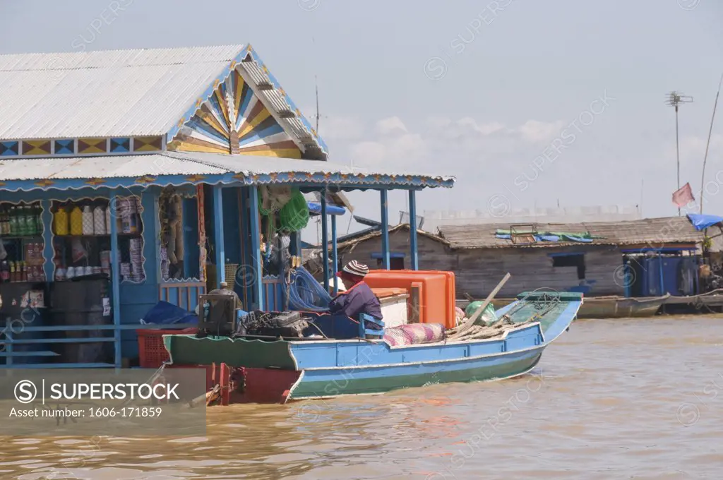 Asia, Cambodia, lake Tonle Sap, floating village , man in a boat in front of floating shop ,