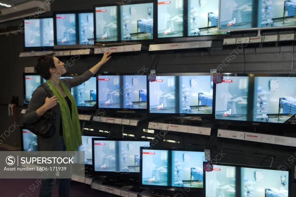 France, Paris, Darty, woman estimating the televisions