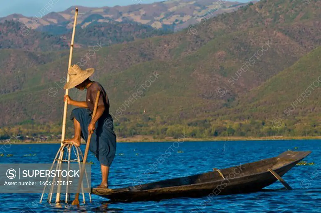 Myanmar (Burma), Shan State, Inle lake, Intha fishermen have created an unique way to move on the water : standing up on a leg at the back of a canoe, they lean the other on a stick that they guide with their ankle, the foot behind, thanks to their keepne
