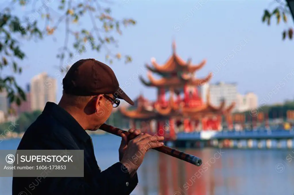 Taiwan,Kaohsiung,Man Playing Flute at Lotus Lake