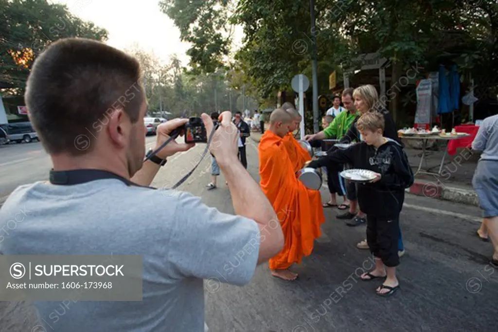 Thailand,Chiang Mai,Tourists making Donations of Food to Monks