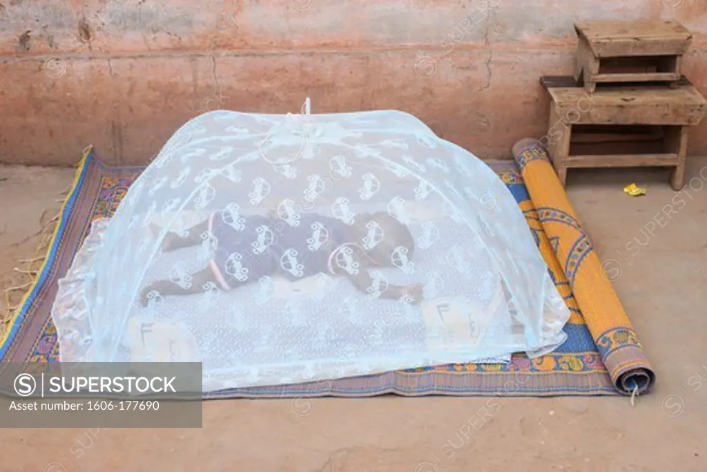Baby sleeping under a mosquito net Lome. Togo.