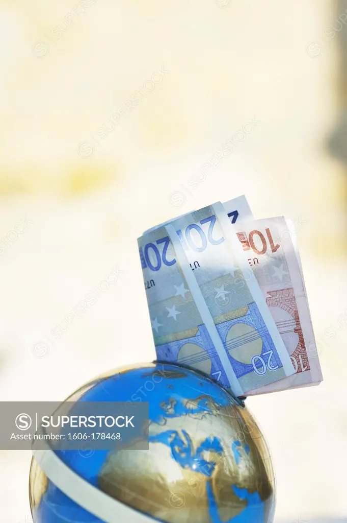Euro bank-notes in a moneybox world globe